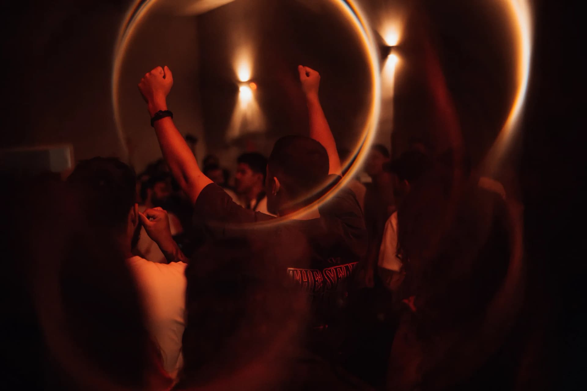 Jovens com os punhos erguidos sob um halo de luz vermelha