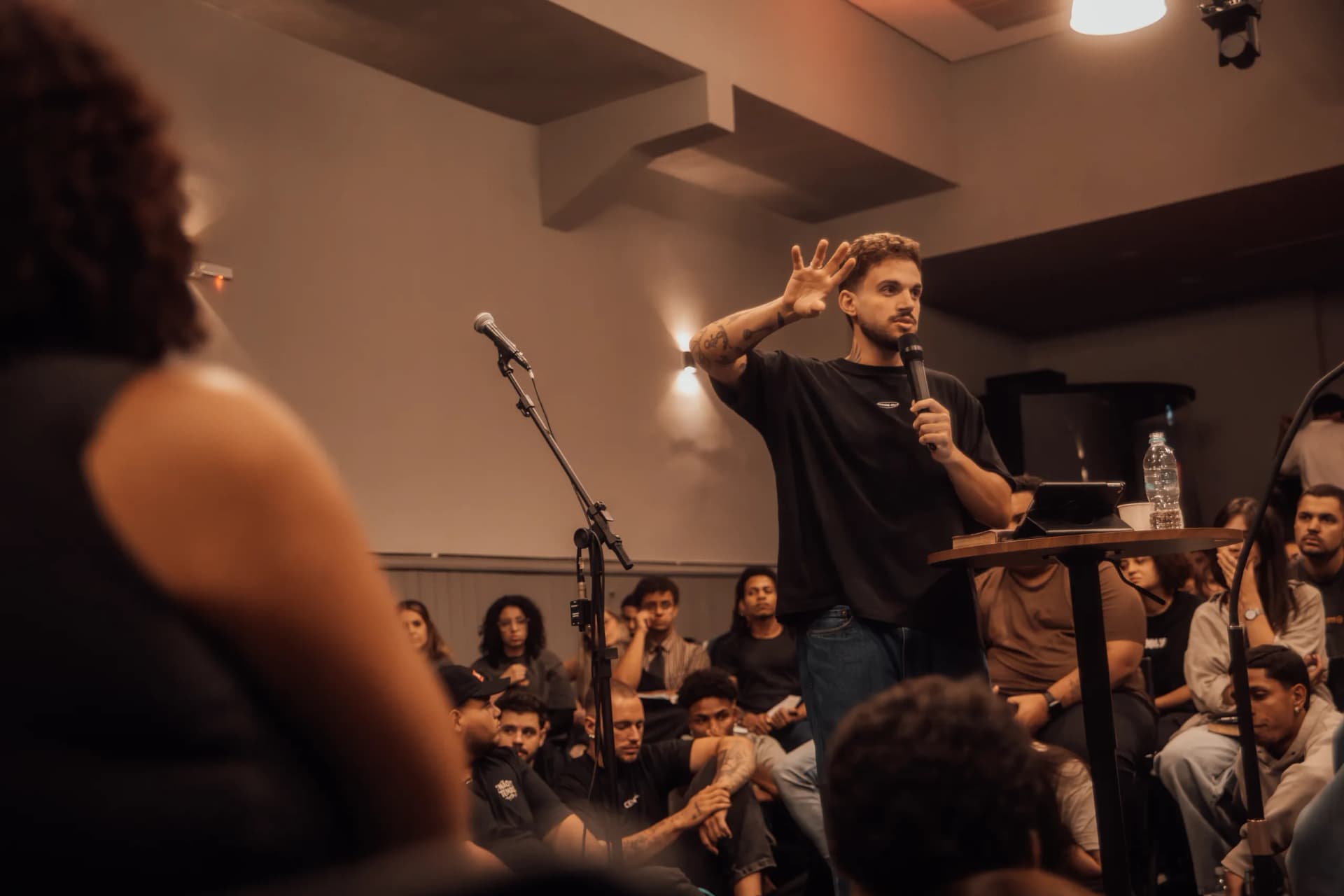 Pregador ensinando para uma plateia de jovens sentados