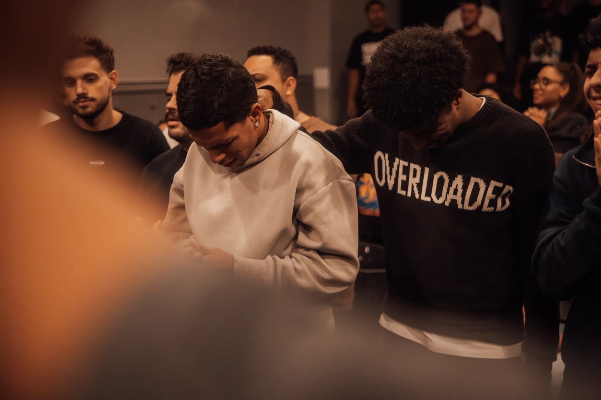 Jovens orando por um rapaz de moletom