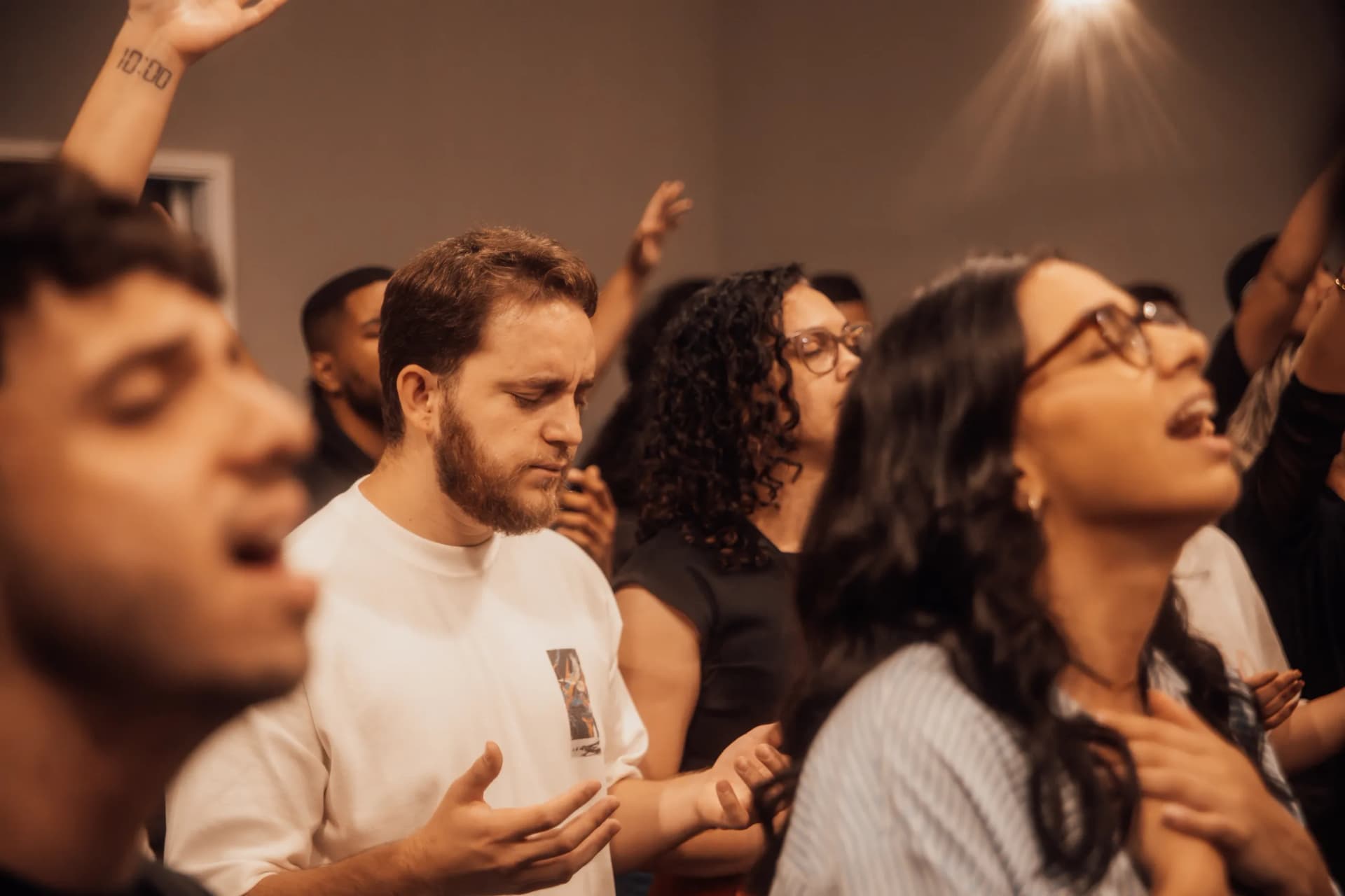 Rostos de jovens em adoração, de olhos fechados