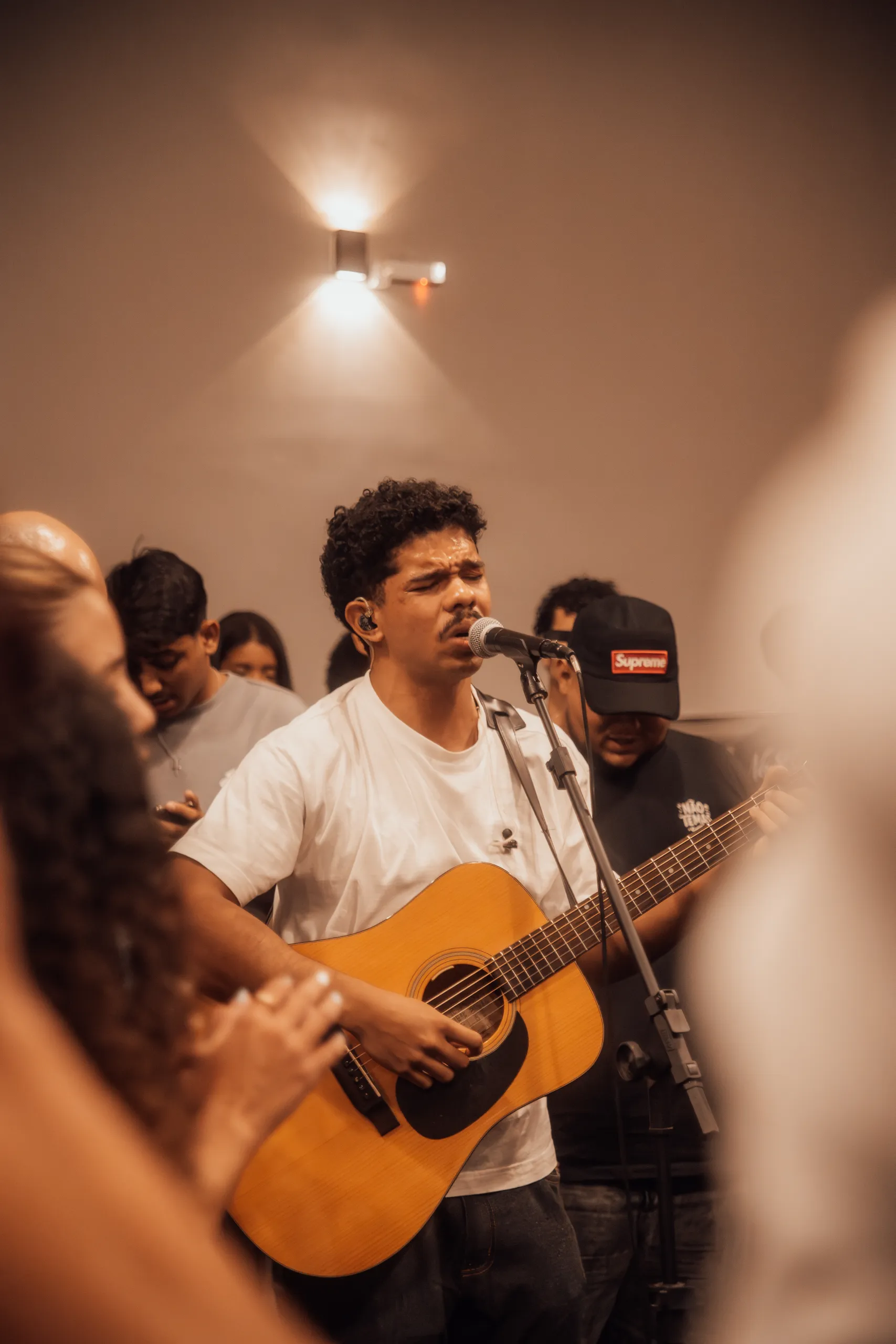 Jovem tocando violão e cantando em adoração