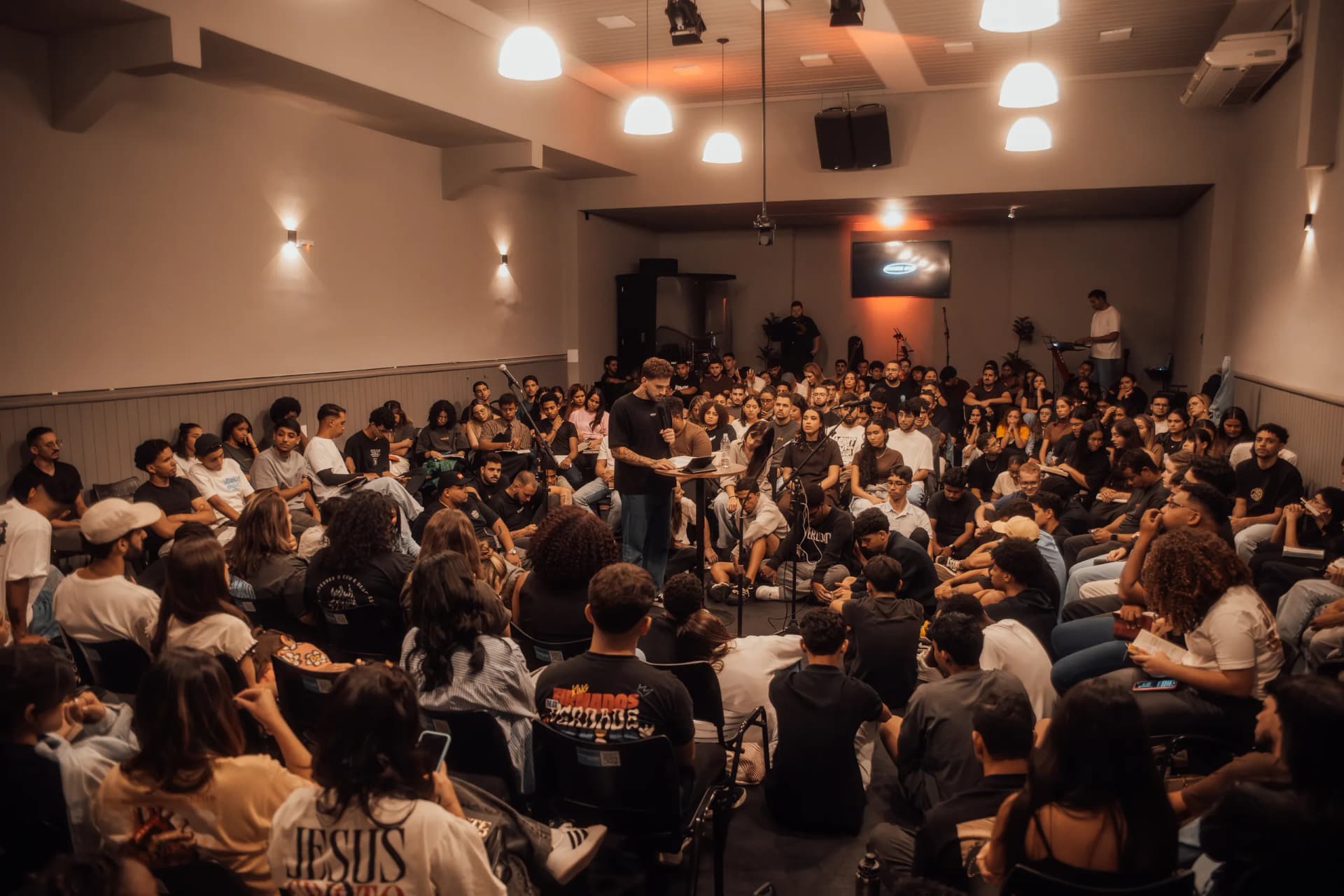 Sala cheia de jovens reunidos para buscar a Deus